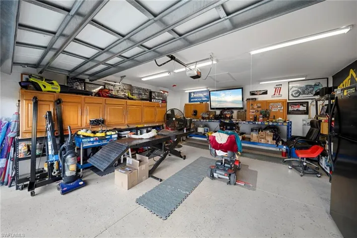 Garage featuring freestanding refrigerator and a workshop area