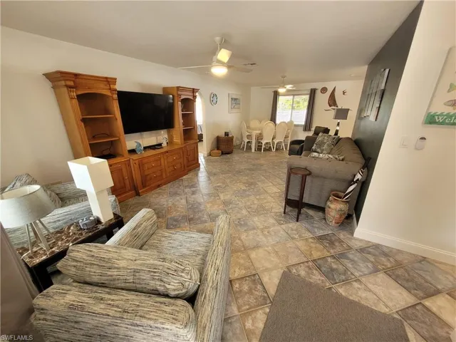 Living area featuring baseboards and a ceiling fan
