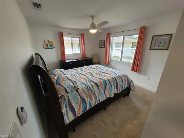 Carpeted bedroom featuring baseboards and a ceiling fan