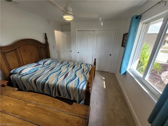 Bedroom with carpet flooring, ceiling fan, and a closet