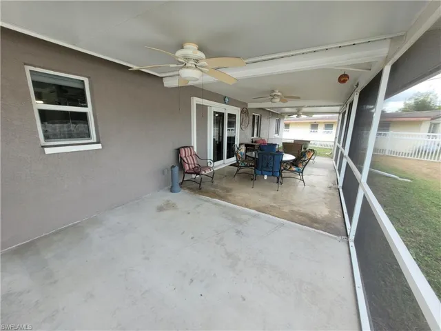 View of patio with a sunroom, outdoor dining area, and a ceiling fan