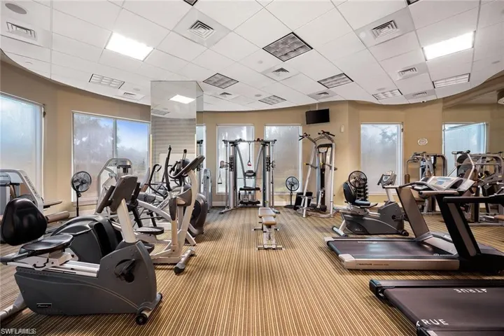 Workout area with light carpet and a paneled ceiling