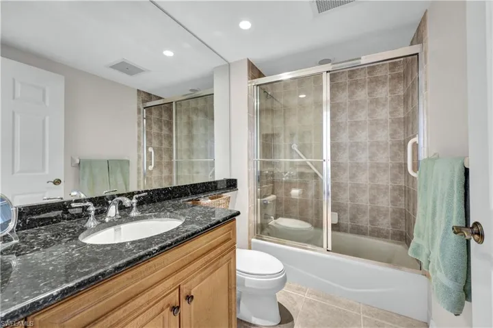 Full bathroom - enclosed tub / shower combo, granite vanity, and tile  floors