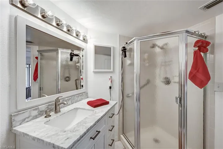 Beautifully remodeled primary / master bath with newer vanity, large sink, solid surface countertops newer and walk in shower with grab bar
