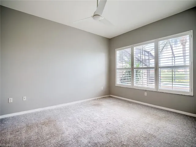 Spare room featuring carpet flooring, ceiling fan, and a healthy amount of sunlight