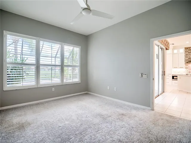 Tiled empty room with plenty of natural light and ceiling fan