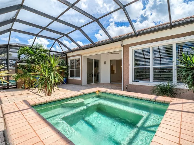 View of pool featuring ceiling fan and glass enclosure