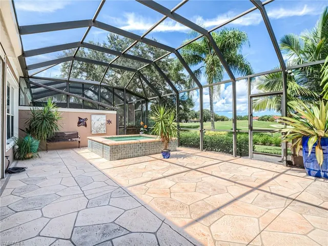 View of patio / terrace with glass enclosure and an in ground hot tub