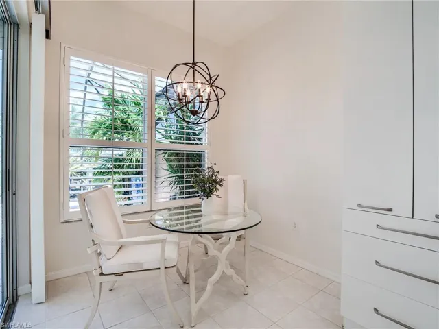 Dining area featuring plenty of natural light, light tile patterned floors, and an inviting chandelier