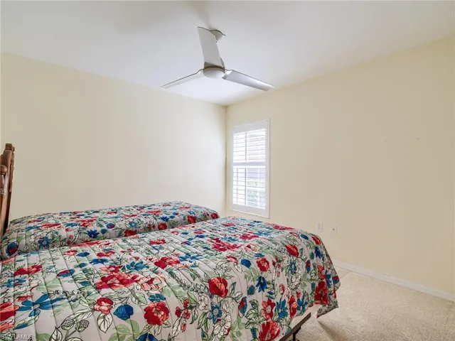 Carpeted bedroom featuring ceiling fan