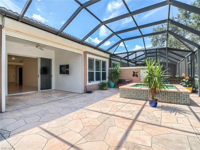 View of patio / terrace featuring ceiling fan and a lanai