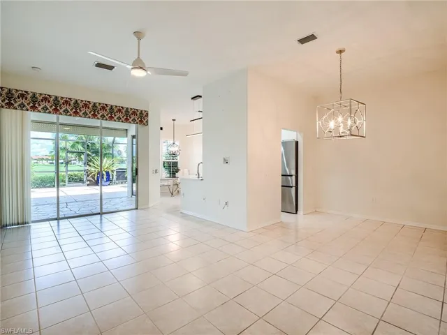 Unfurnished room with sink, ceiling fan with notable chandelier, and light tile patterned floors