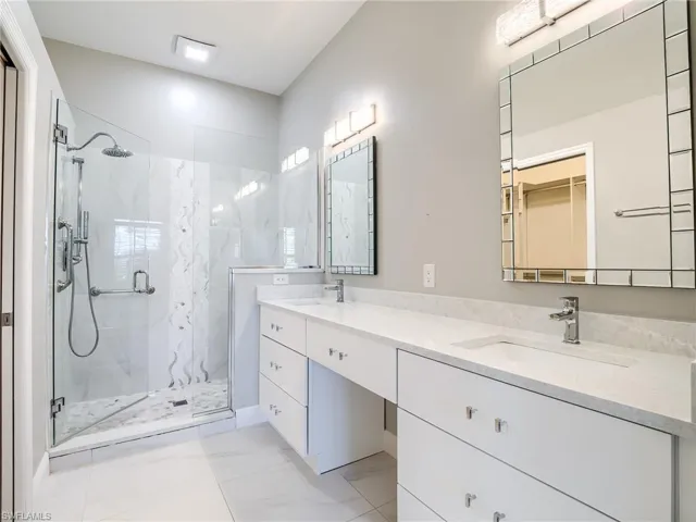 Bathroom with tile patterned flooring, an enclosed shower, and vanity