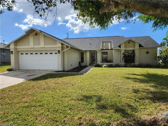 View of front of house featuring stucco siding, a front yard, driveway, a garage, and a shingled roof