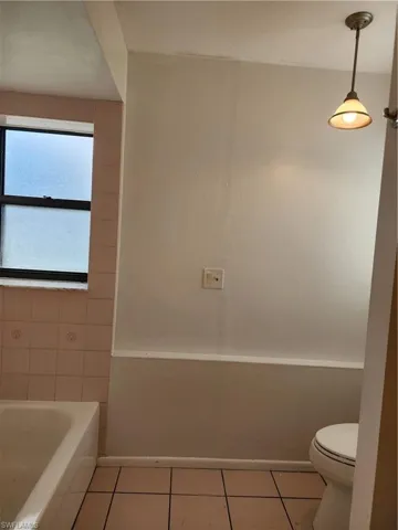 Full bath featuring tile patterned floors and a tub