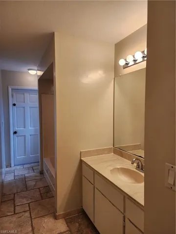 Full bathroom featuring stone tile floors and vanity