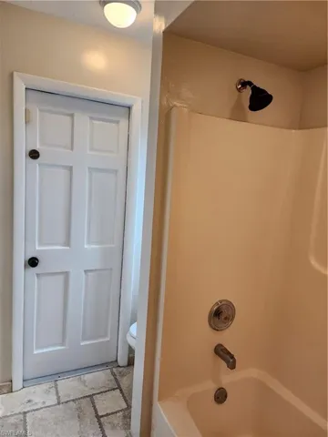 Bathroom with toilet and bathing tub / shower combination