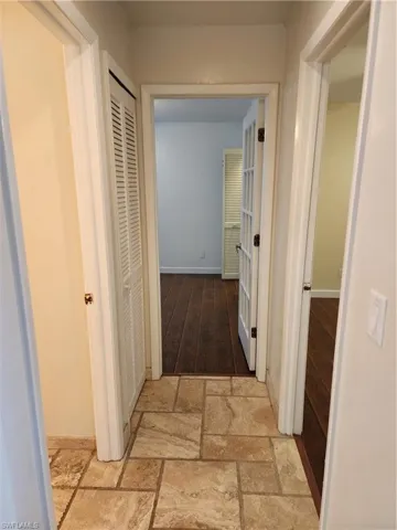 Hallway featuring baseboards and stone tile flooring