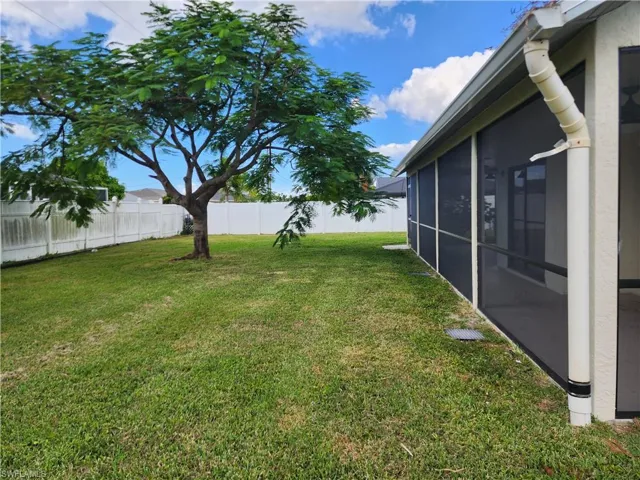 Fenced backyard with a sunroom