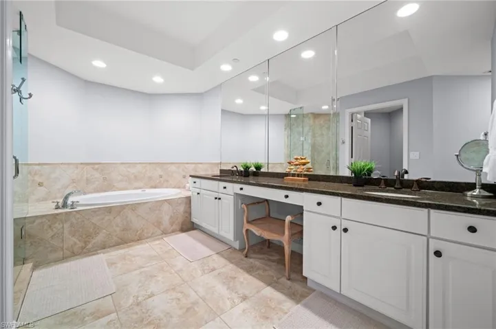 Full bath featuring a stall shower, double vanity, recessed lighting, a bath, and light tile patterned floors