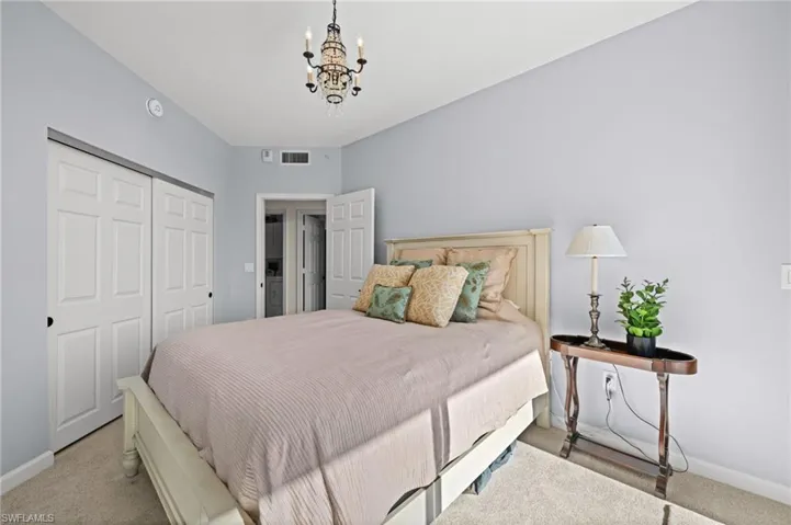 Carpeted bedroom featuring a closet and a chandelier