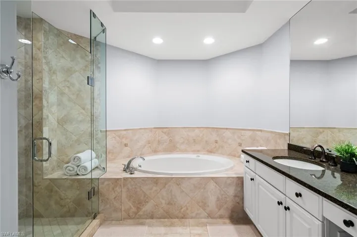 Bathroom featuring vanity, a bath, a shower stall, and recessed lighting