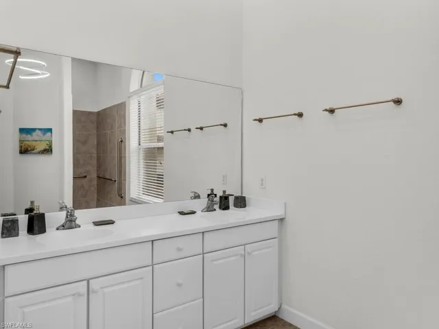 Bathroom with vanity and tiled shower