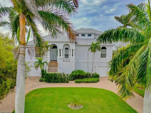 View of front of property with a front yard, a garage, and a porch