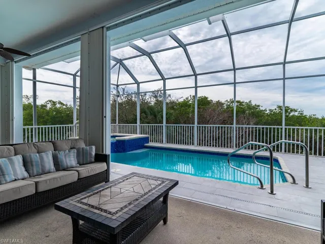 View of pool featuring a patio, an outdoor living space, glass enclosure, and ceiling fan