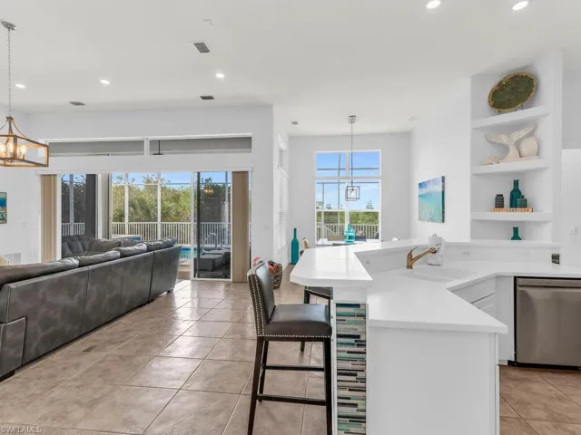 Kitchen with sink, a wealth of natural light, decorative light fixtures, and stainless steel dishwasher