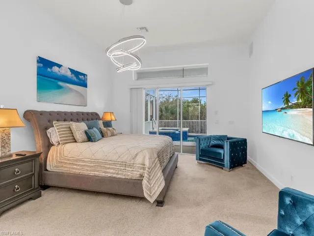 Bedroom with a chandelier, light carpet, and access to exterior