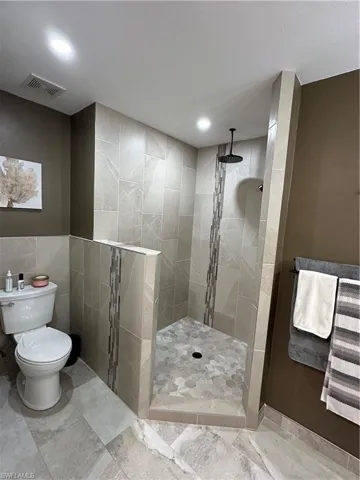 Full bathroom featuring walk in shower and tile walls