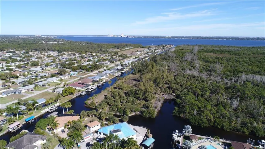 Aerial overview of property's location featuring a nearby body of water and nearby suburban area