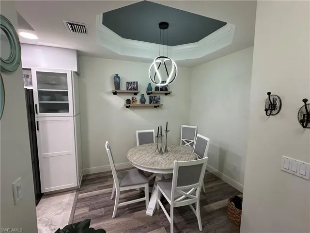 Dining room featuring a tray ceiling, and ornamental molding