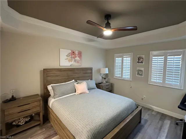 Bedroom featuring a tray ceiling, ornamental molding, and ceiling fan