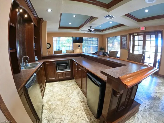 Kitchen featuring open shelves, a peninsula, dark brown cabinetry, stainless steel appliances, and coffered ceiling