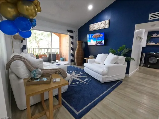 Living room featuring vaulted ceiling, wood finished floors, and recessed lighting