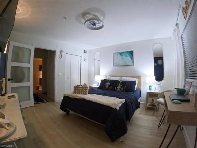 Bedroom with wood finished floors and a closet