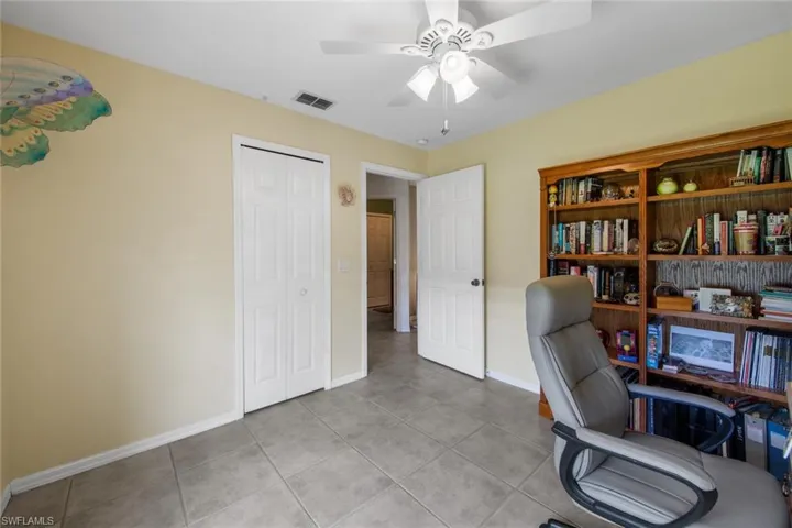 Office space with light tile patterned floors, baseboards, and ceiling fan