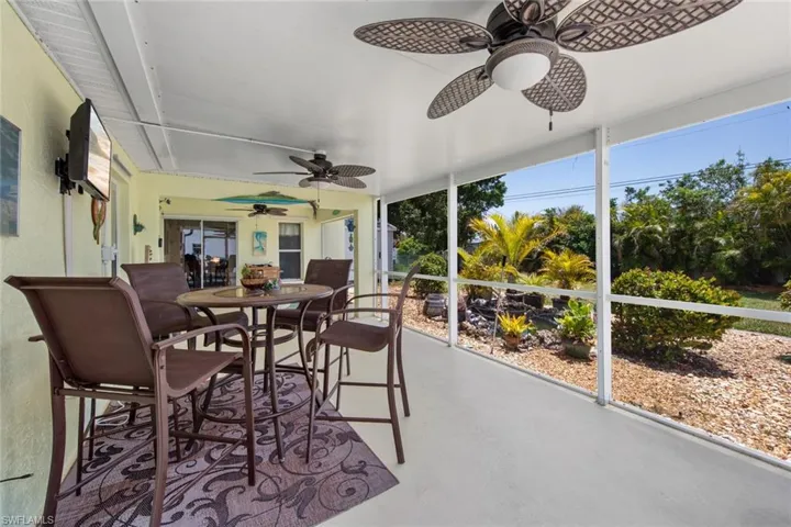 Sunroom / solarium featuring ceiling fan, outdoor dining space, and plenty of natural light