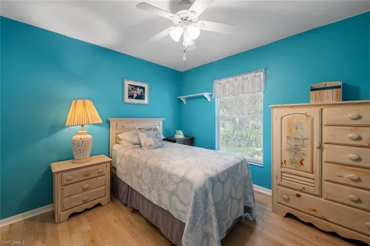 Bedroom with light wood-style flooring, baseboards, and a ceiling fan