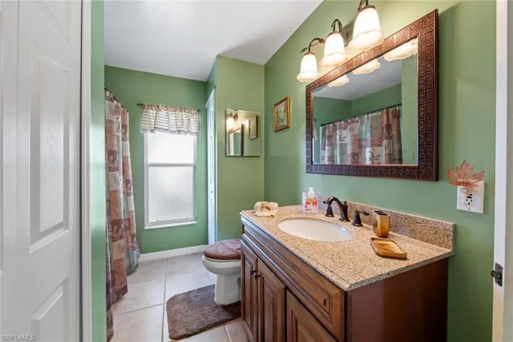 Bathroom with vanity, toilet, and tile patterned floors