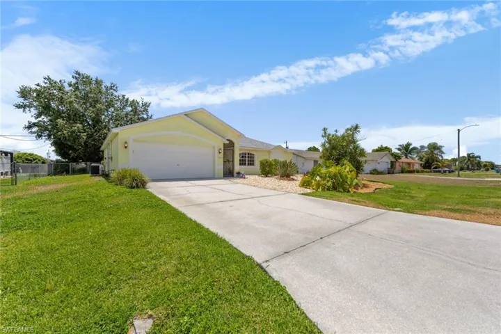 Ranch-style house featuring concrete driveway, an attached garage, stucco siding, and central air condition unit