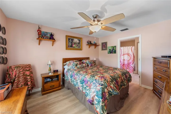 Bedroom featuring light wood-type flooring, ceiling fan, and baseboards