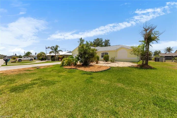 View of front of home featuring concrete driveway, a front lawn, and a garage