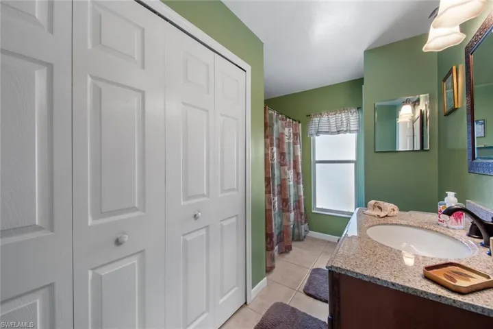 Bathroom with tile patterned floors, vanity, a closet, and a shower with curtain
