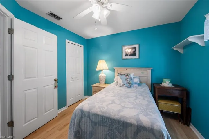 Bedroom with wood finished floors, a closet, a ceiling fan, and baseboards