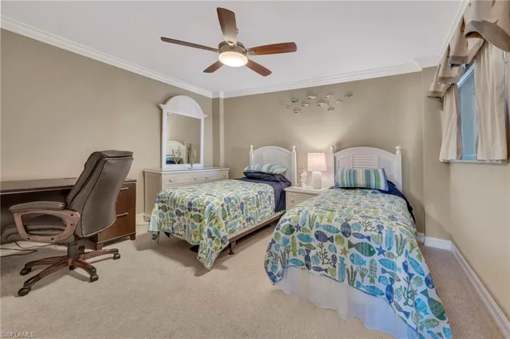 Bedroom with crown molding, light carpet, ceiling fan, and an office area