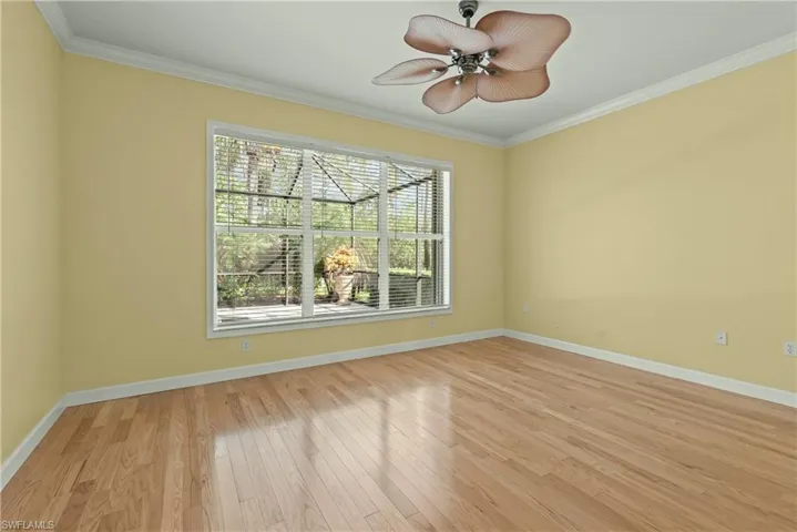 Master bedroom with crown molding and light wood-style floors