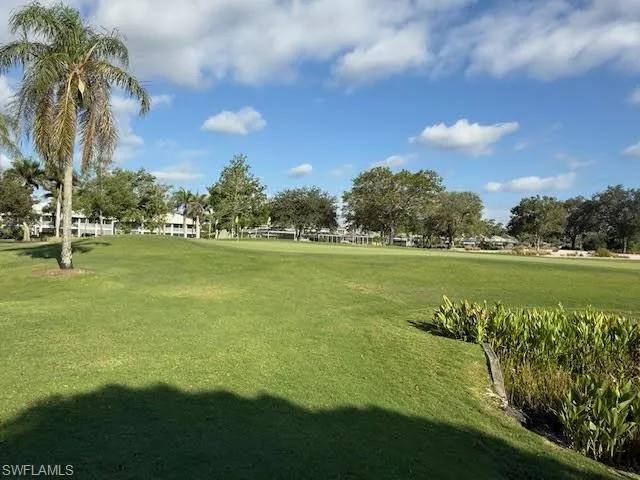 View of property's community with a lawn and view of golf course